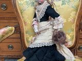 a doll that is sitting on a chair in a room