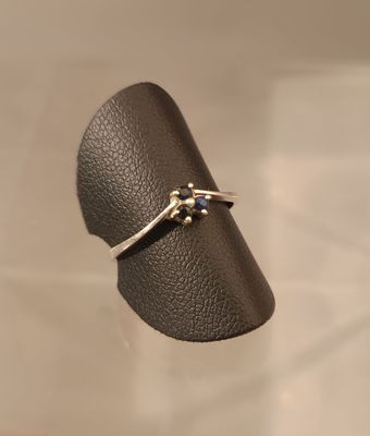 bague en argent sterling sertie de saphirs bleus, présentée sur un support en cuir noir