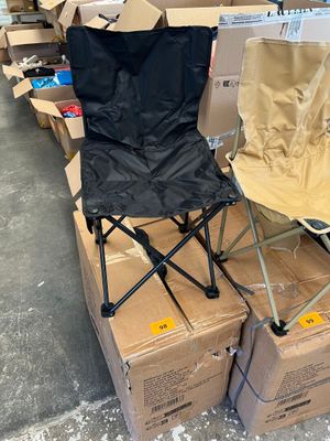 deux chaises pliantes posées sur des cartons dans un entrepôt