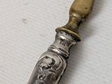 a silver spoon with a gold handle sitting on a table