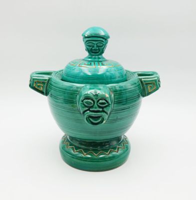 green ceramic bowl with a lid and a face on the lid