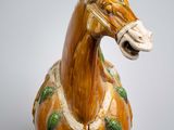 a ceramic horse that is standing up on a table