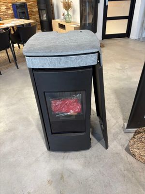 une poubelle noire posée par terre à côté d'une table