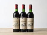 trois bouteilles de vin posées sur une table en bois
