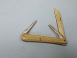 a small pocket knife with a wooden handle on a table