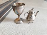 une théière en argent et une théière en argent posées sur une table