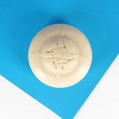 un cachet de cire sur un morceau de papier posé sur une surface bleue
