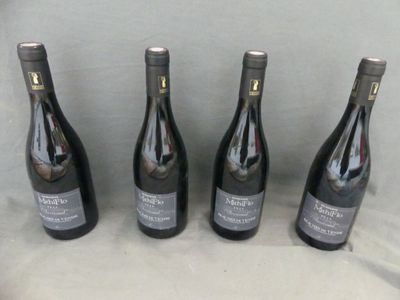 four bottles of wine are lined up on a table