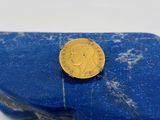 une pièce d'or posée sur un morceau de marbre bleu