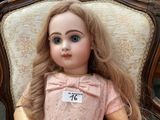 a doll that is sitting on a chair with a tag on it