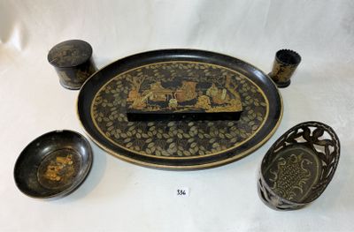 une assiette noire et dorée, ornée d'un motif noir et doré