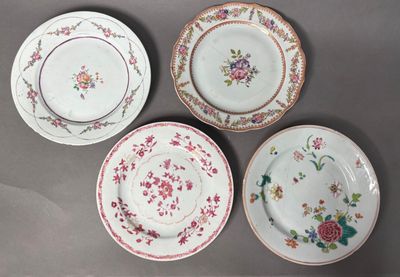 four plates with floral designs are arranged on a gray surface