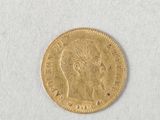 a close up of a gold coin on a white surface