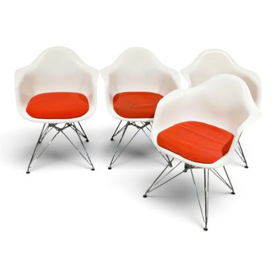 four white chairs with orange cushions and chrome legs on a white surface