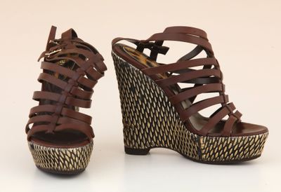pair of women ' s brown wedged sandals with woven straps