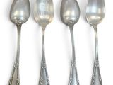 four spoons are lined up in a row on a white surface