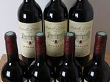 six bottles of red wine sit in a wooden crate on a table