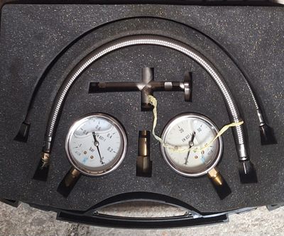 two gauges and a hose in a black case