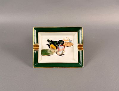 une image représentant une petite assiette verte et blanche sur laquelle figure l'image d'un oiseau