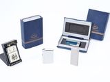trois livres, une horloge et un appareil électronique posés sur une surface blanche