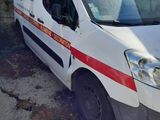 a white van with a red stripe parked in front of a building