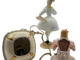 a figurine of a woman with a chair and a teddy bear