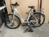 un vélo blanc garé dans un garage, contre un mur