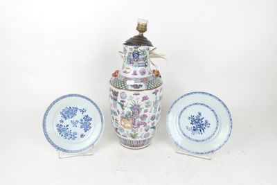 a blue and white vase and two plates on a table