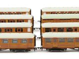 two brown and white train cars sitting side by side