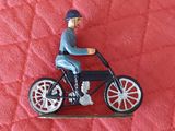 une figurine représentant un homme à moto, assis sur une couverture rouge
