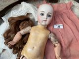 a doll and a doll doll laying on a bed