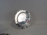 an antique silver plate on a table with a pair of scissors