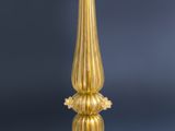 a gold candle holder with a white candle on it