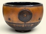 un bol marron et noir orné d'une horloge
