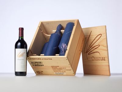 une bouteille de vin à côté d'une caisse en bois et d'une bouteille de vin