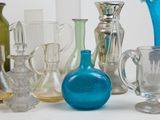 many different colored glass vases sitting on a table