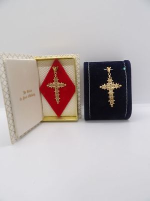 deux petites boîtes, une croix et un livre posés sur une surface blanche