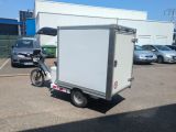 a small white box trailer parked in a parking lot