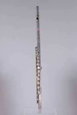 a flute that is sitting on a stand in front of a gray wall