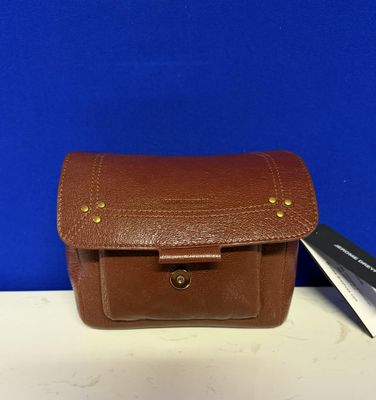 une trousse à outils en cuir marron, avec une paire de ciseaux posée à côté