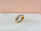 une bague en or et diamants posée sur une surface en marbre
