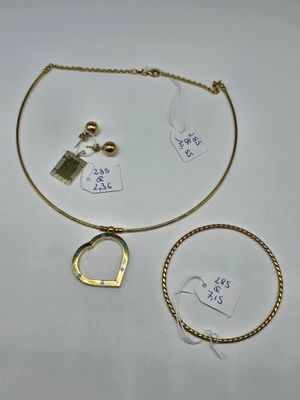 two gold necklaces, a bracelet, and a ring on a table