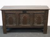 an old wooden chest sitting on top of a carpeted floor