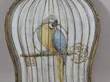 une cage contenant un oiseau bleu et jaune