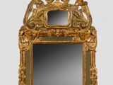 un cadre doré contenant un miroir, posé sur une surface blanche