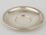 une assiette en argent ornée d'un motif circulaire sur le bord