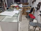 une vitrine en verre au milieu d'une pièce où se trouvent des tabourets