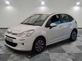 la petite voiture blanche est garée sur un sol en damier