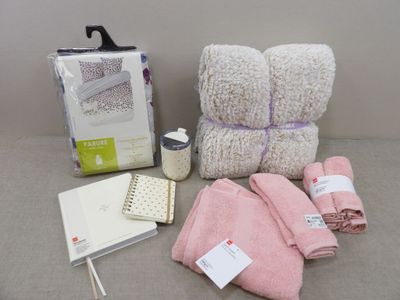 une pile de serviettes, un cahier et une tasse de café posés sur une table