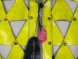 a close up of a yellow and white leather vest with a tag on it